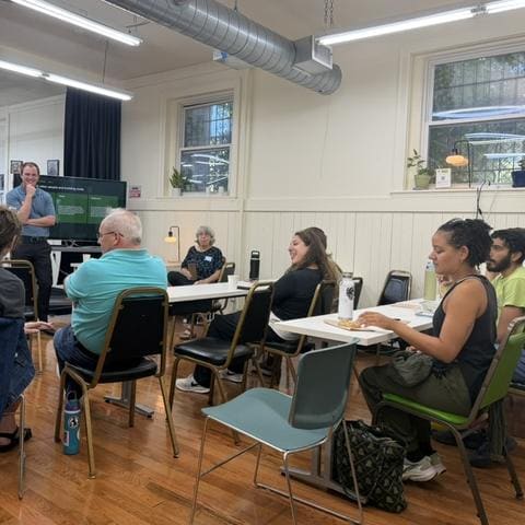 Attendees talking in small groups after a presentation